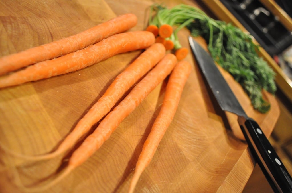 carrots on a wooden cutting board with a knife