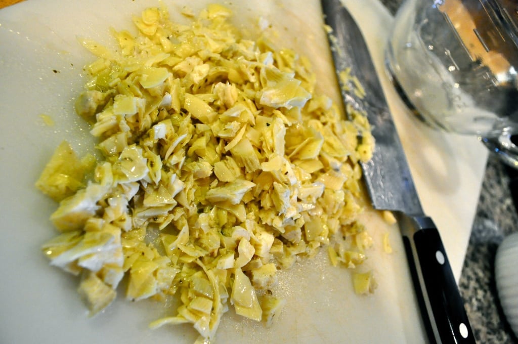 chopped artichoke hearts on a white cutting board