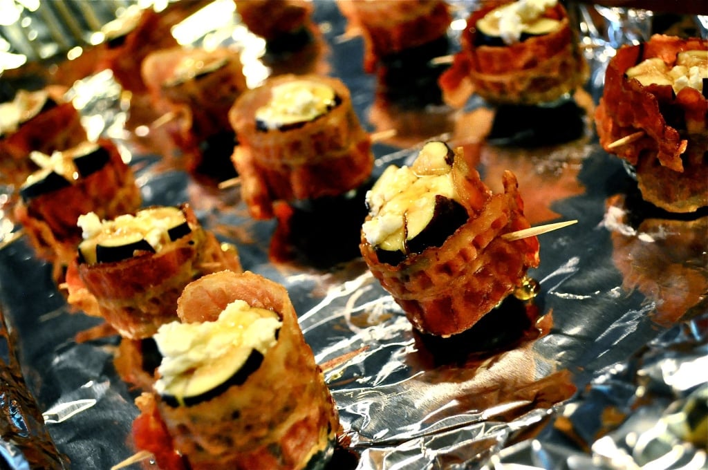 multiple figs stuffed with goat cheese and wrapped in bacon on a foil lined baking sheet