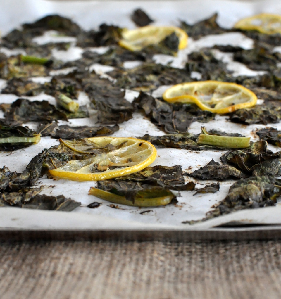 turnip greens and lemon slices on parchment paper and a sheet pan