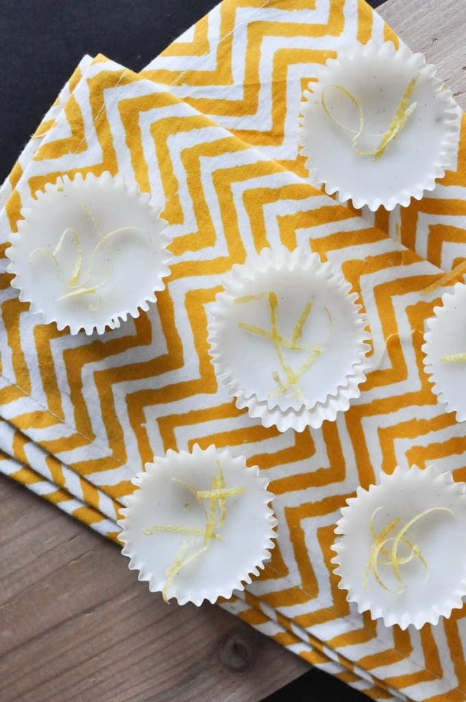 overhead view of multiple white lemon vanilla meltaways topped with lemon zest and placed on a yellow zig zag napkin