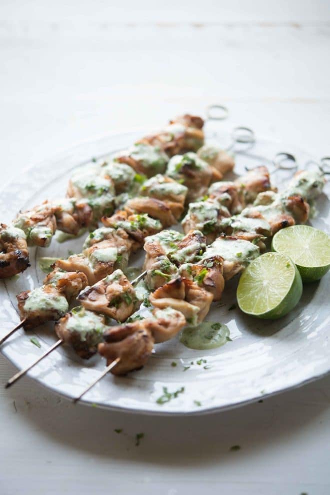 skewers of Citrus Chicken with Cilantro Garlic Sauce on a white plate