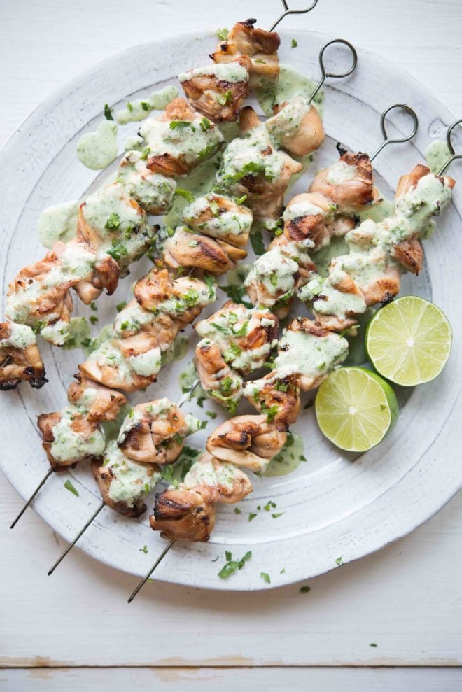 overhead view of skewers of Citrus Chicken with Cilantro Garlic Sauce on a white plate