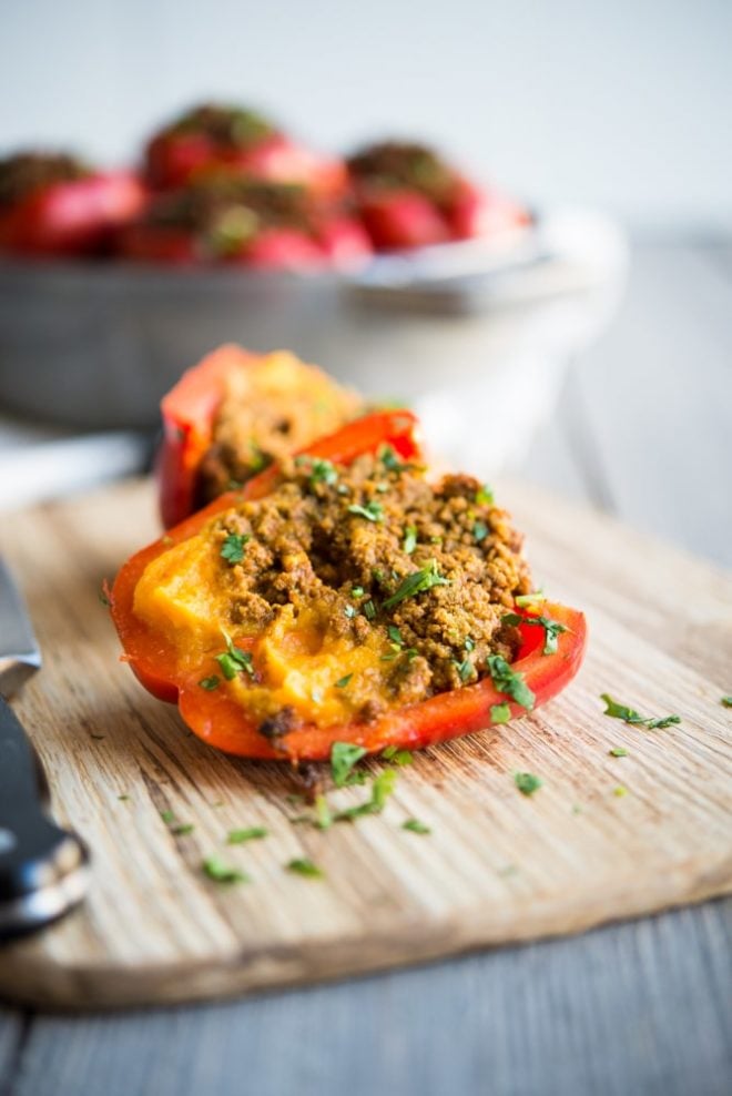 a halved Curried Beef & Butternut Squash Stuffed Pepper on a cutting board