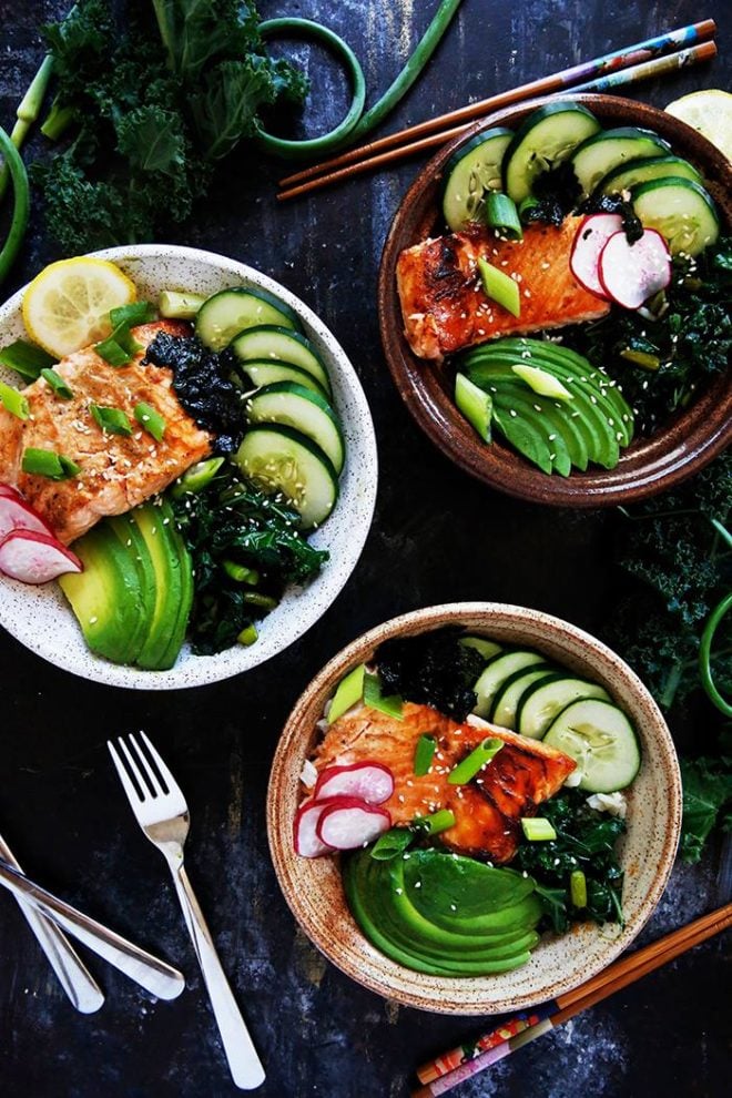 three grilled fish bowls with garlic scapes and kale