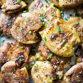 overhead view of smashed crispy golden breakfast potatoes, sprinkled with green chives