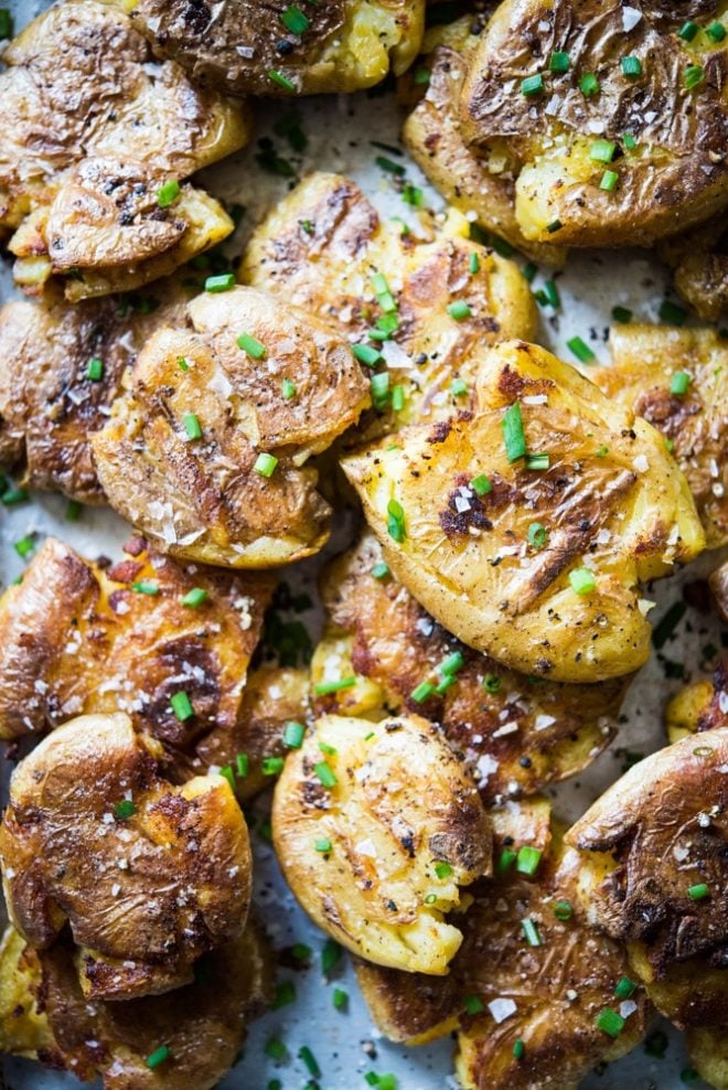 overhead view of smashed crispy golden breakfast potatoes, sprinkled with green chives