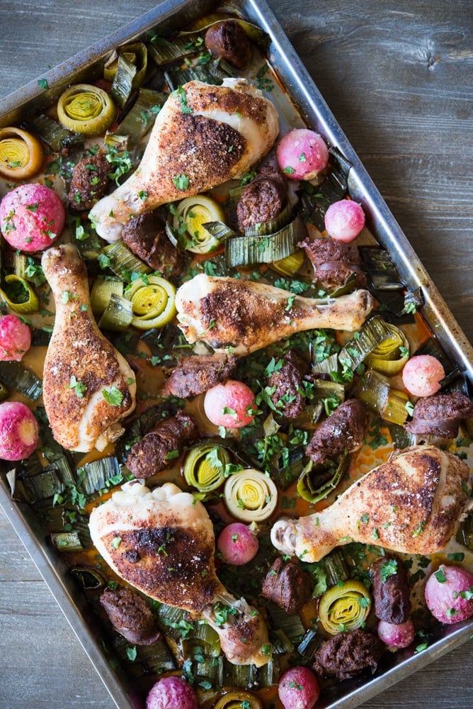 chorizo and chicken sheet pan dinner with chicken drumsticks, radishes, and leeks