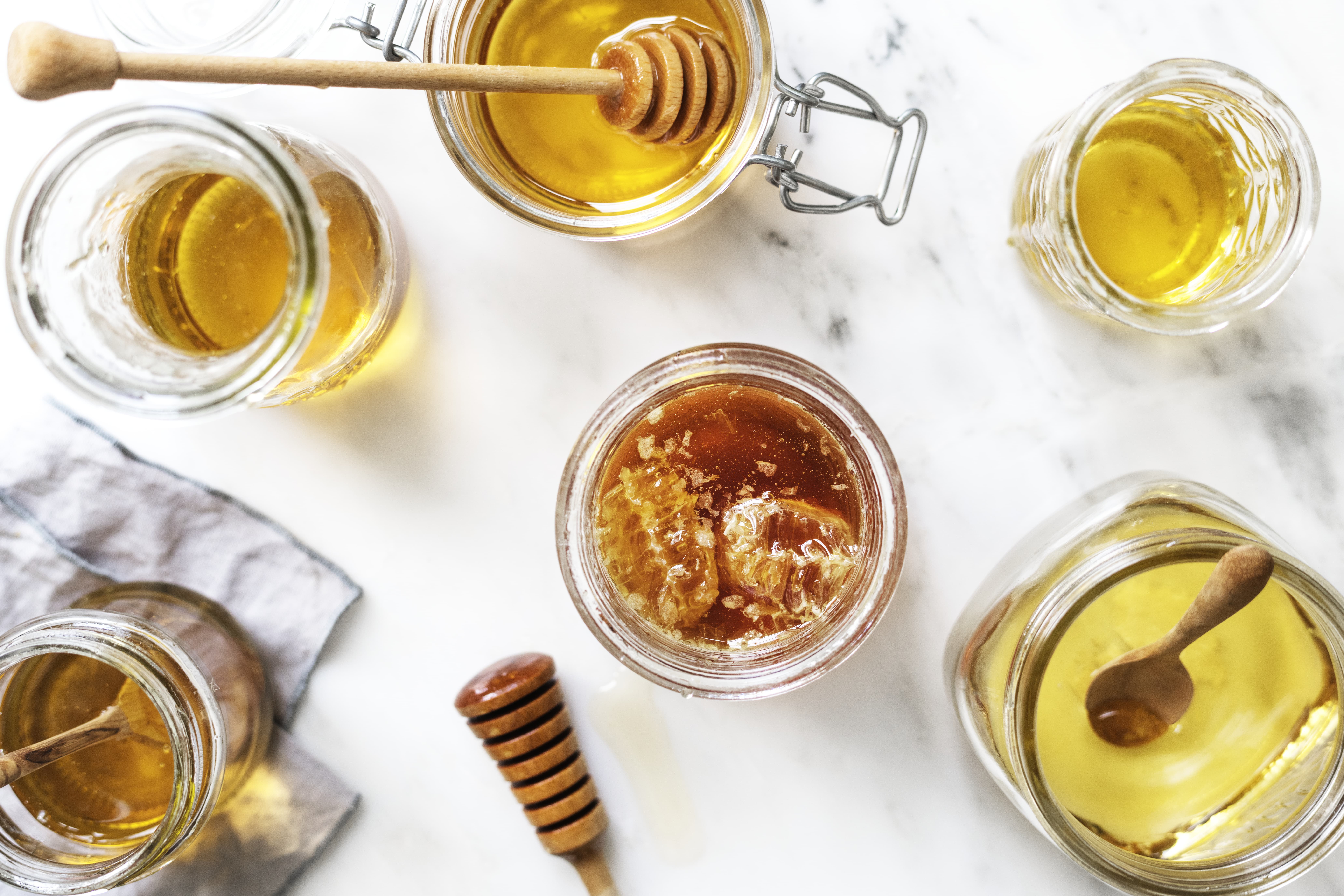 honey in pots on a marble board