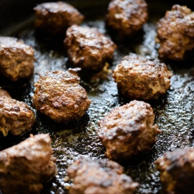 a cast iron skillet filled with chicken liver meatballs