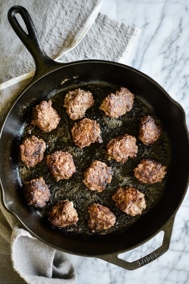 overhead of view of a cast iron skillet filled with chicken liver meatballs