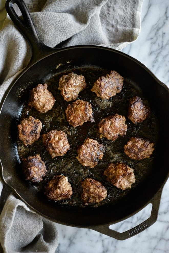 overhead of view of a cast iron skillet filled with chicken liver meatballs