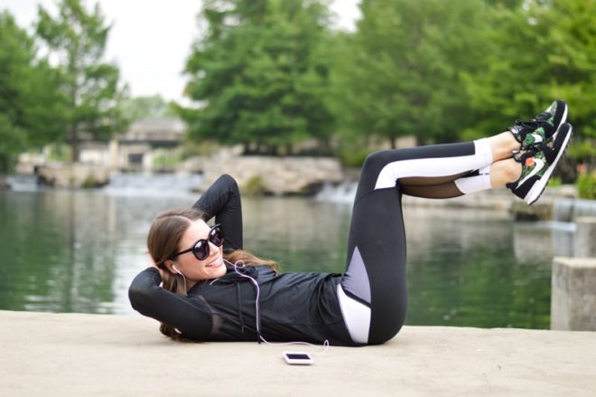 a woman in a fitness outfit in front of a river doing a situp