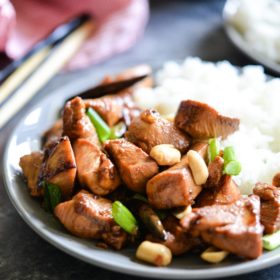 paleo kung pao chicken with rice on a gray plate on a dark gray surface