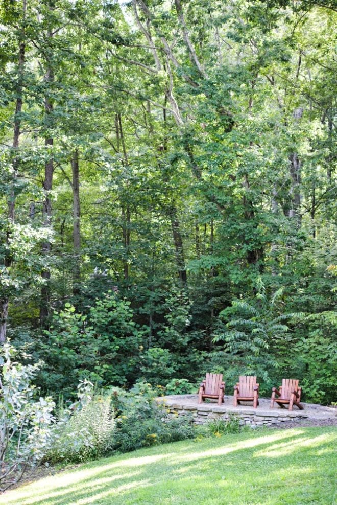 green trees and three Adirondack chairs