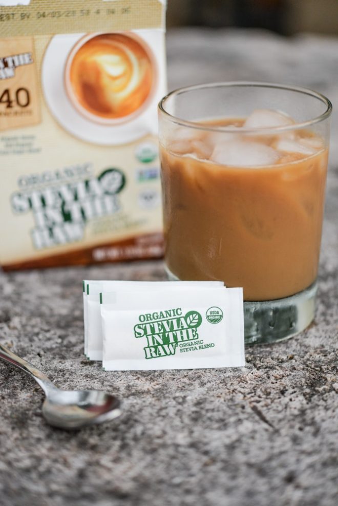 glass cup filled with caramel colored coffee with two packets of stevia in the raw on the table