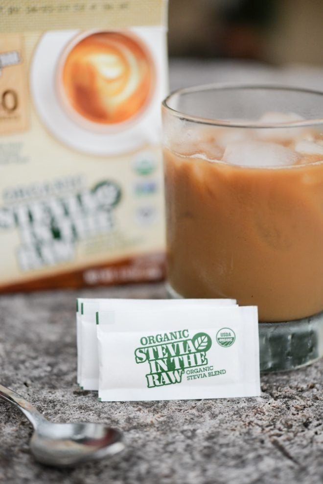 glass cup filled with caramel colored coffee with two packets of stevia in the raw on the table