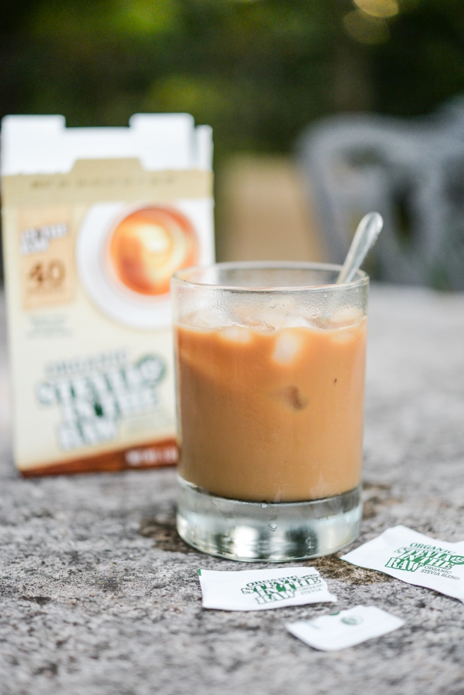 glass cup filled with caramel colored coffee with two packets of stevia in the raw on the table