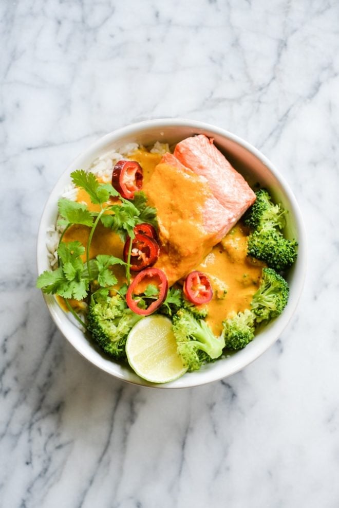 These easy bowl feature quick pan-seared salmon, an Indian coconut curry sauce, steamed broccoli, and rice for an easy one bowl dinner! | Fed & Fit