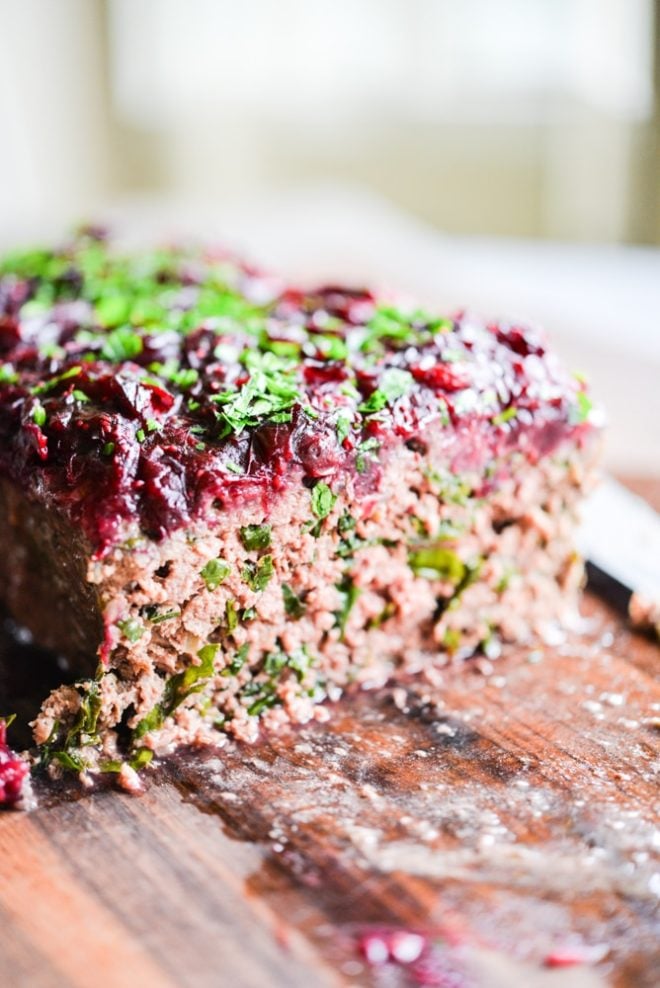 This Paleo bison cranberry meatloaf is the perfect healthy winter comfort food. It is incredibly flavorful, packs a big superfood punch, and the tangy cranberry sauce topping makes it perfectly festive for the holiday season!