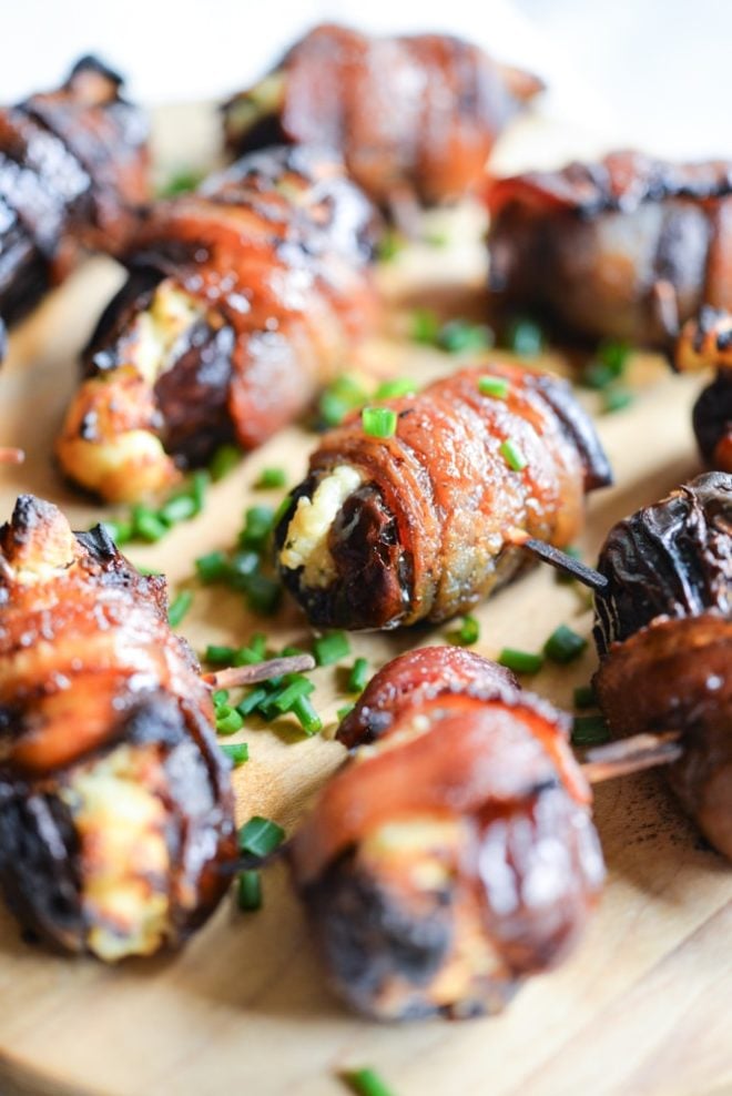 cream cheese bacon dates on a wooden cutting board