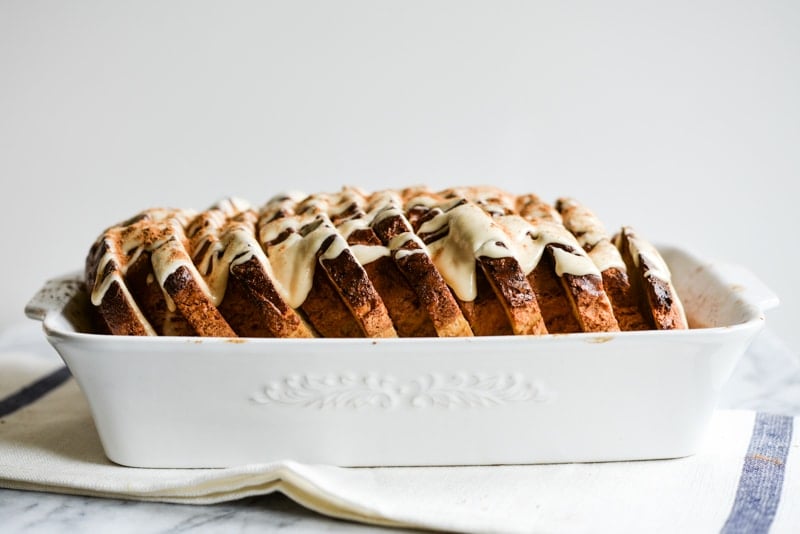 cinnamon french toast bake in a white ceramic dish on a marble surface