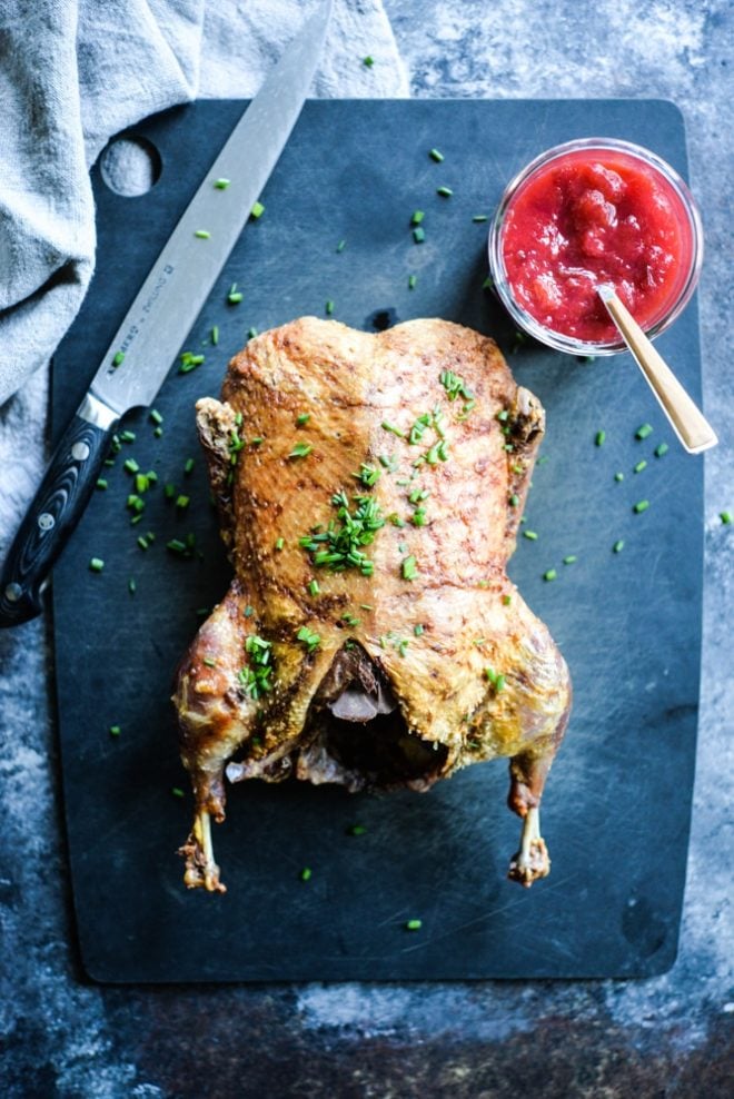overhead view of easy roasted duck with plum sauce on a black cutting board