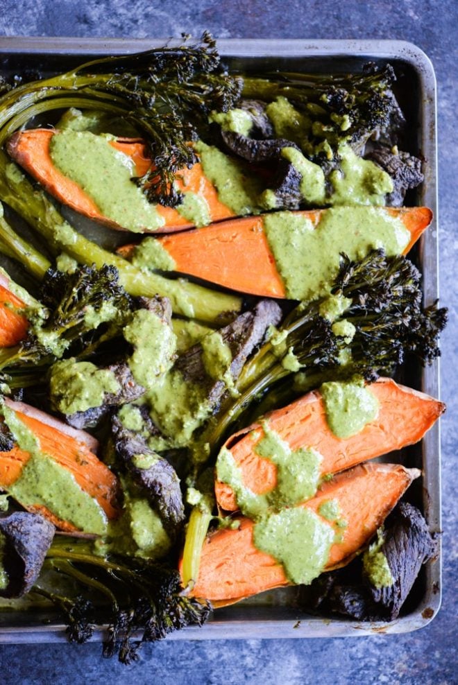 overhead view of chimichurri beef sheet pan dinner with beef, sweet potatoes, and broccolini