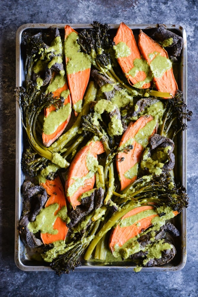 chimichurri beef sheet pan dinner with strips of steak, sweet potatoes, broccolini, and a bright chimichurri sauce