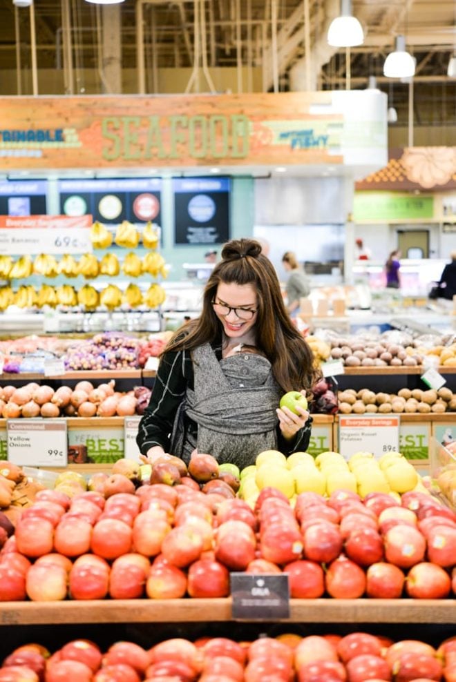 woman wearing a baby and grocery shopping