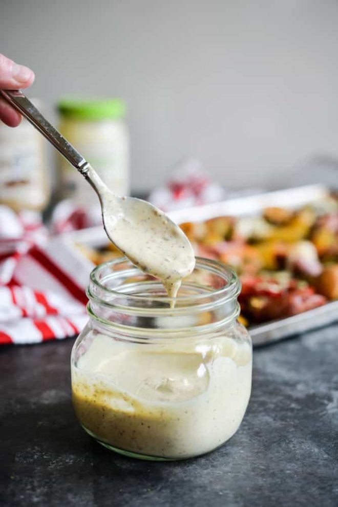 a jar of Cajun Remoulade Sauce being dipped into by a spoon