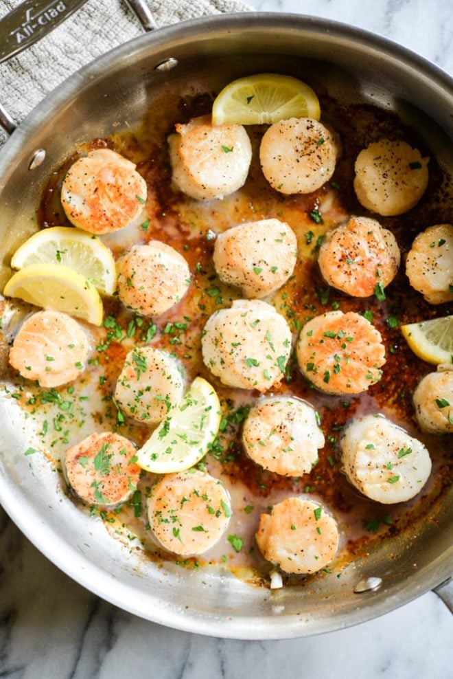 overhead view of easy seared scallops in a stainless steel pan