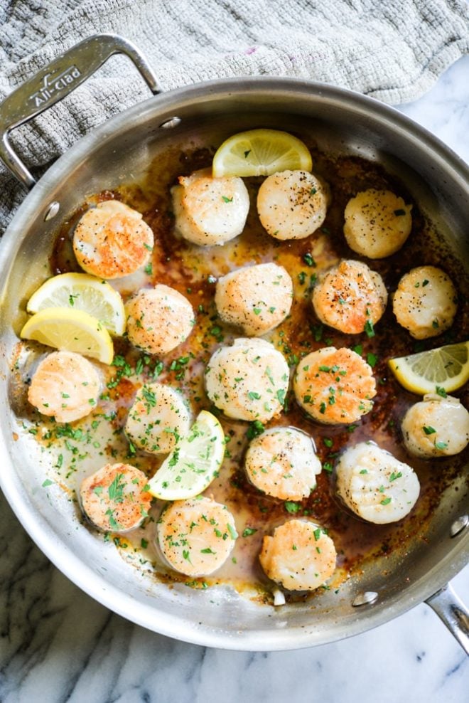 overhead view of easy seared scallops in a stainless steel pan