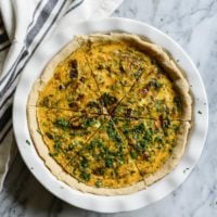gluten-free quiche in a white pie dish on a marble surface