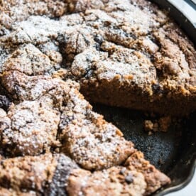 a skillet of chocolate chai swirl coffee cake with one piece missing