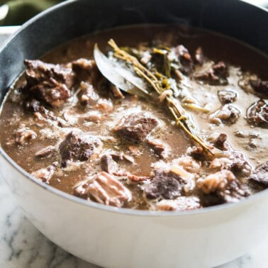 instant pot beef Burgundy in a white cast iron pot on a marble board