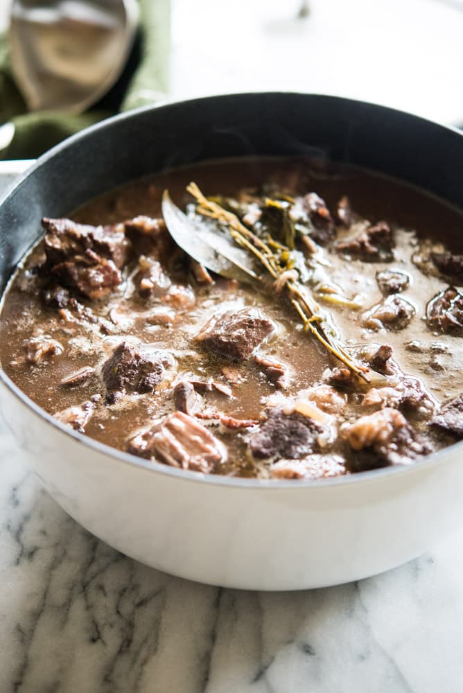 instant pot beef Burgundy in a white cast iron pot on a marble board