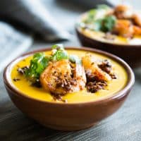 two bowls of chorizo shrimp kabocha squash soup on a grey wooden table