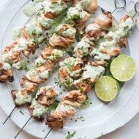 overhead view of skewers of Citrus Chicken with Cilantro Garlic Sauce on a white plate