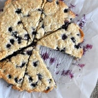 overhead view of blueberry scones on parchment paper cut into triangles