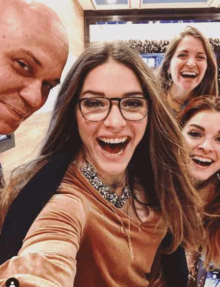 a "selfie" with three long haired smiling women and a bald man