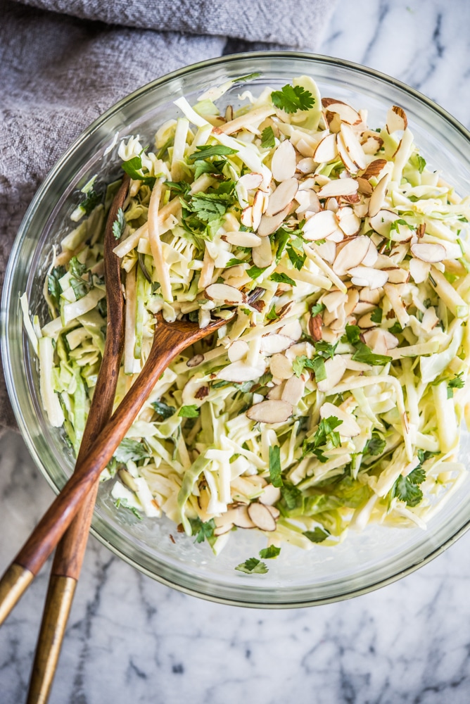 green apple coleslaw in a bowl on a marble countertop