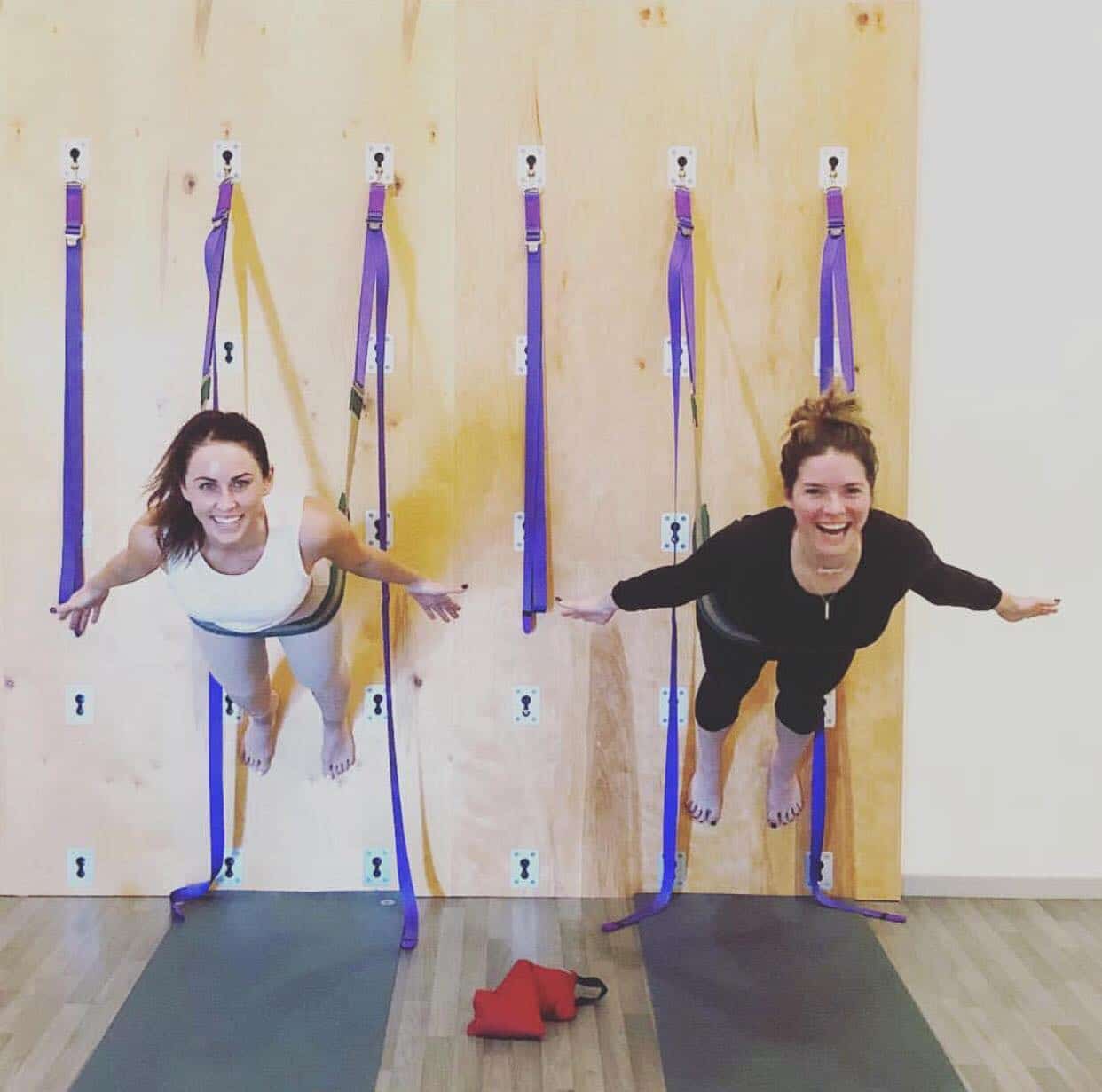 two smiling women doing an aerial fitness class at a wellness retreat in phoenix