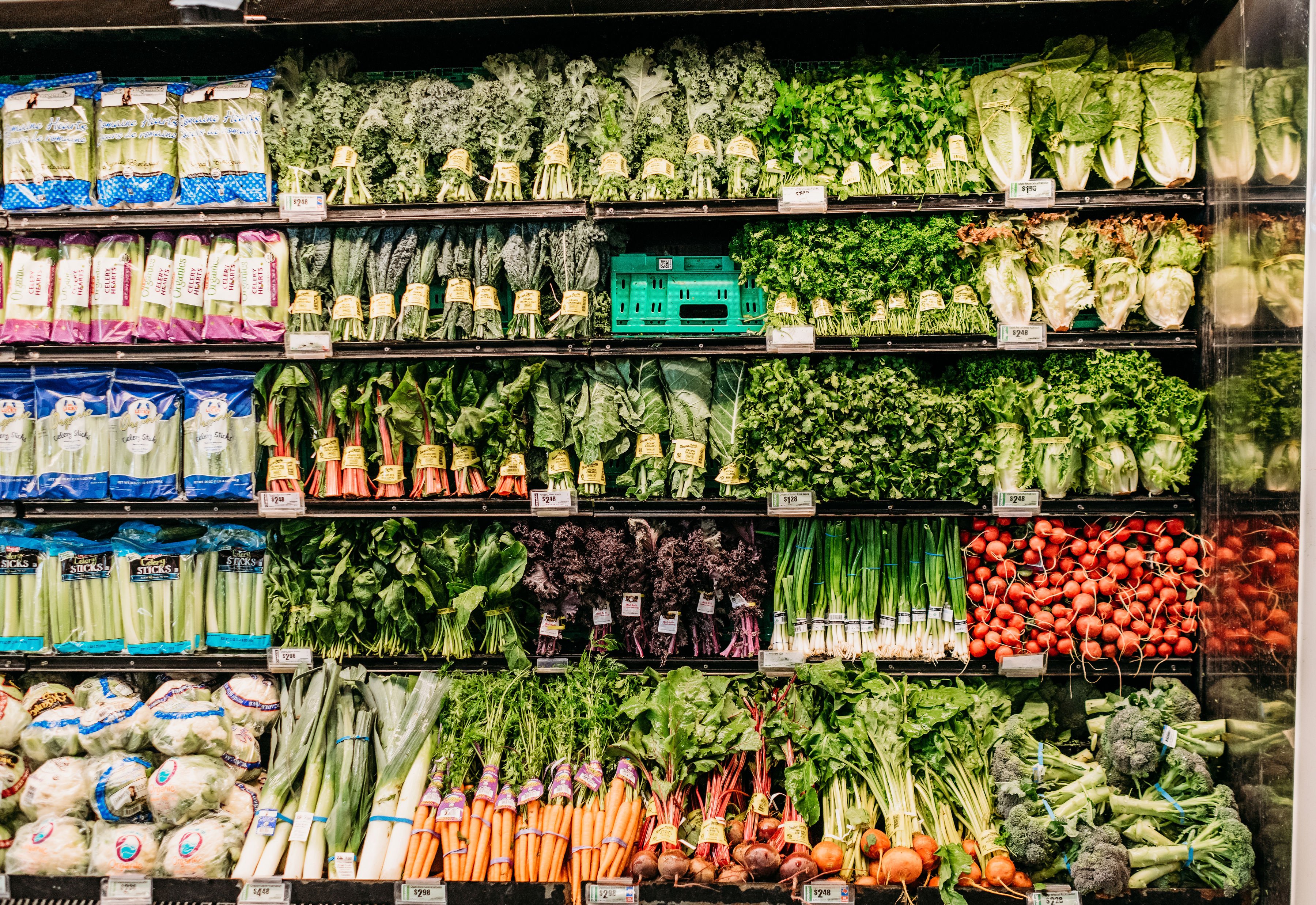 produce aisle at the grocery store with leeks, carrots, lettuces, radishes - where to buy groceries online