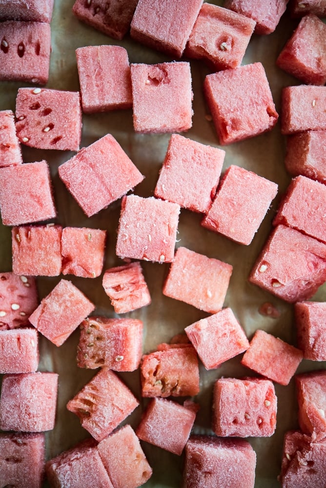 Cubed watermelon frozen on a sheet pan.