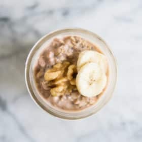banana nut overnight oats in a mason jar topped with banana slices and walnuts