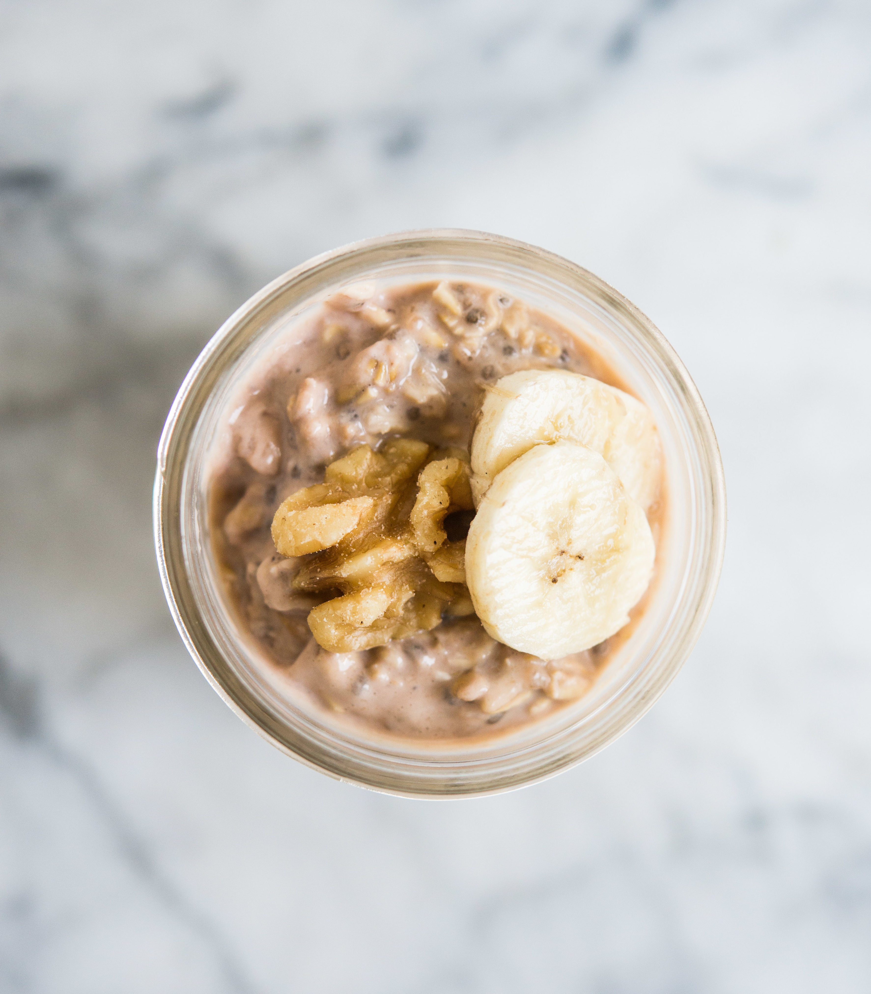 banana nut overnight oats in a mason jar topped with banana slices and walnuts