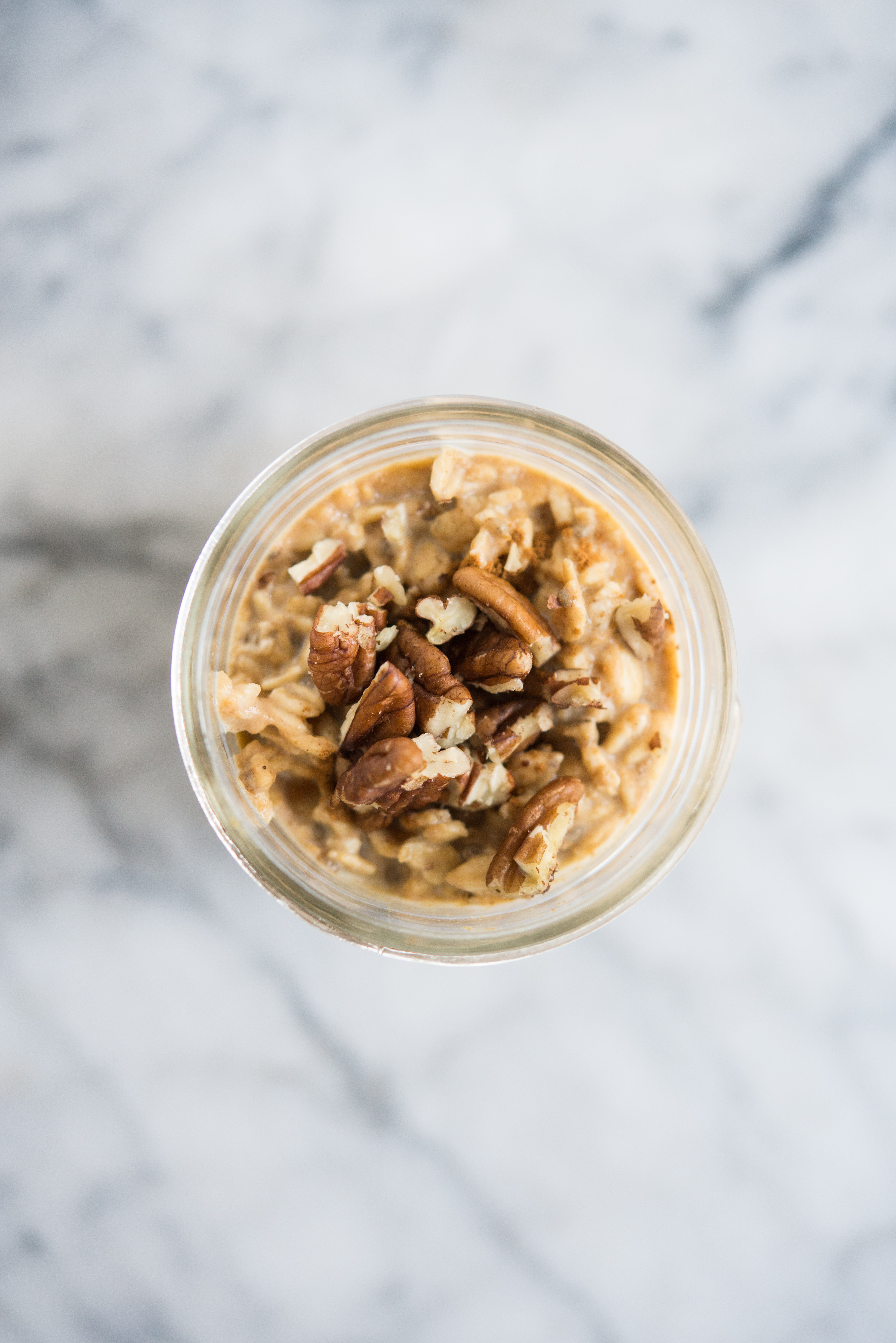 pumpkin spice overnight oats in a mason jar with pecans on top