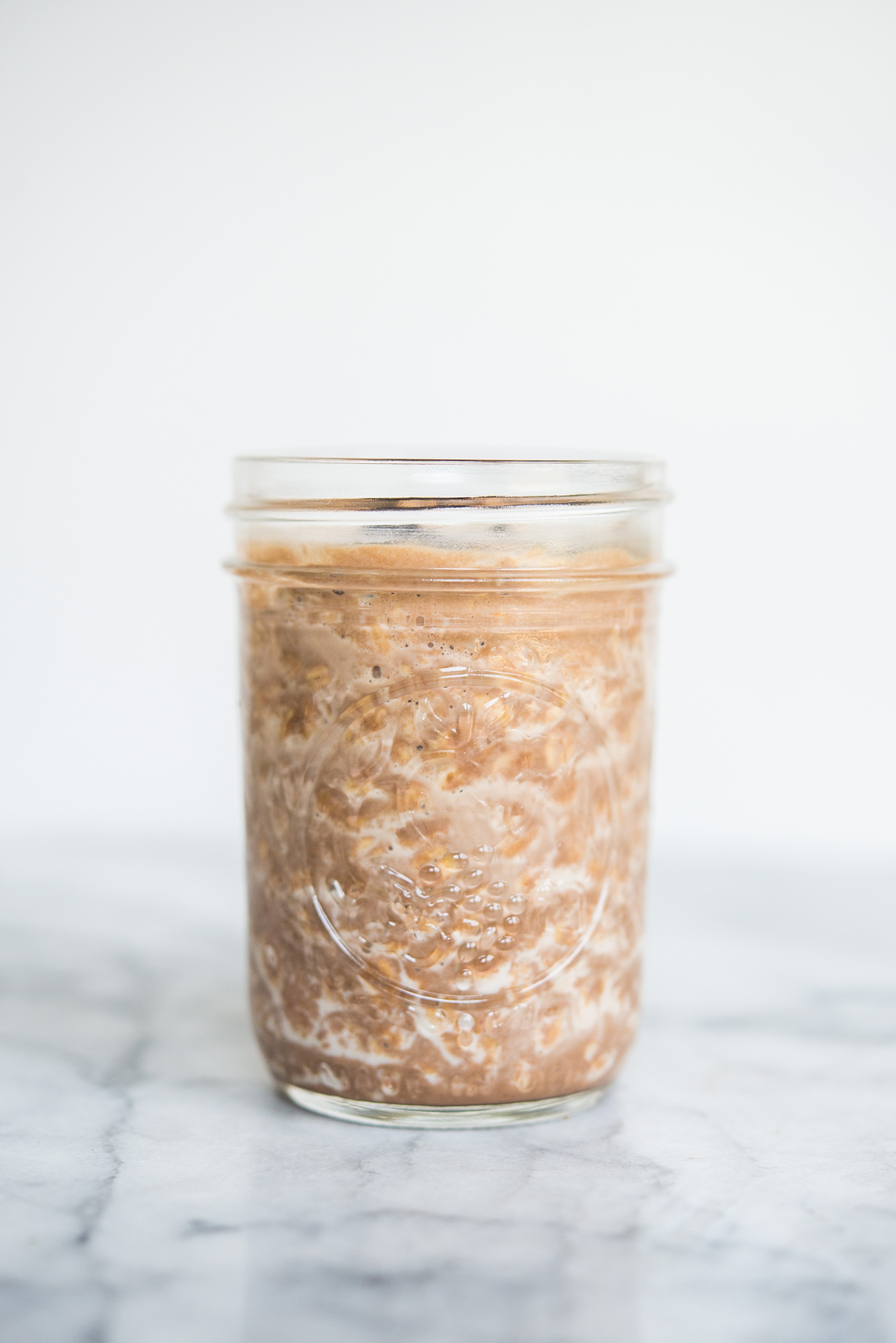 chocolate peanut butter overnight oats in a mason jar sitting on a marble counter