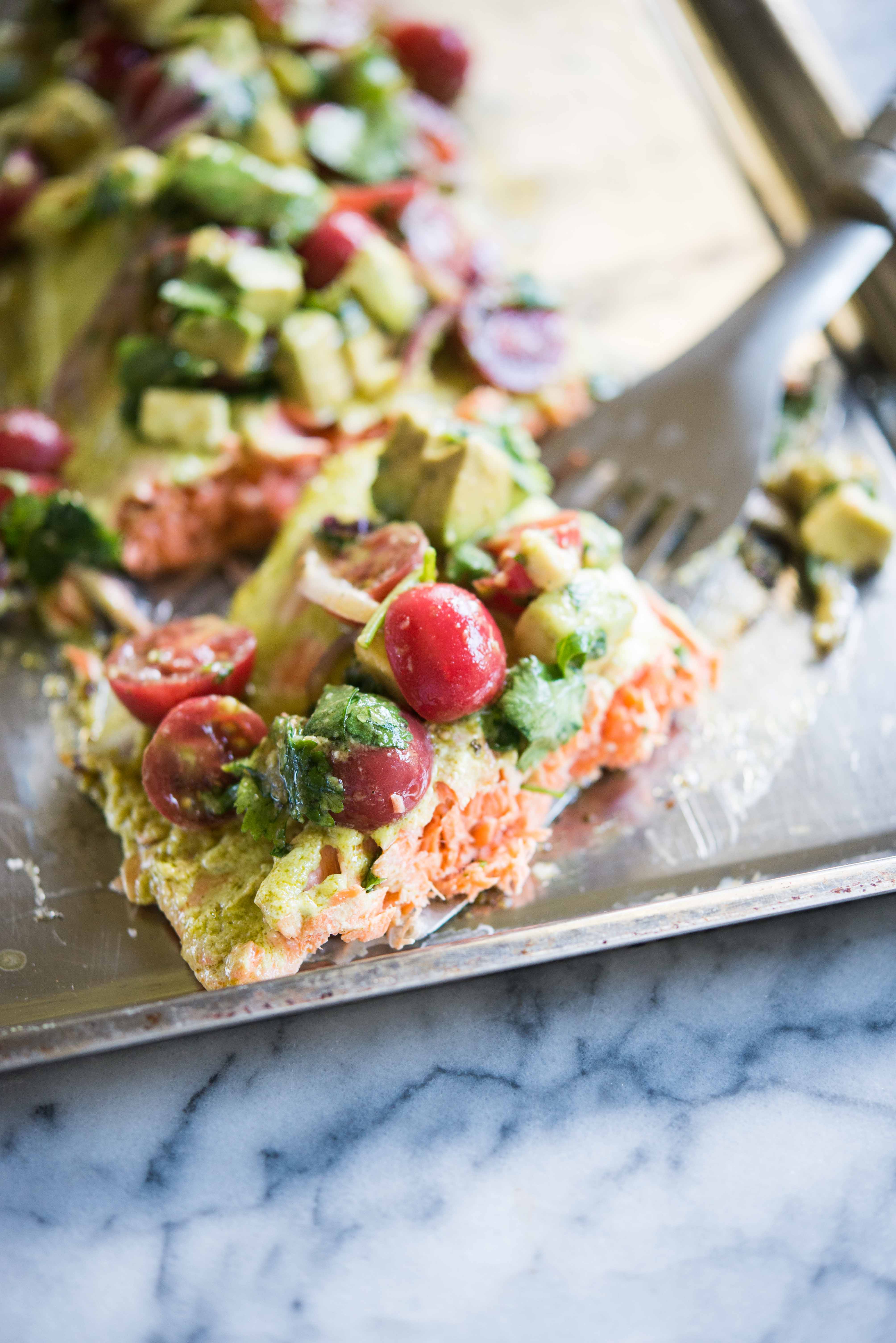 cilantro lime baked salmon topped with tomato avocado salsa on a sheet pan